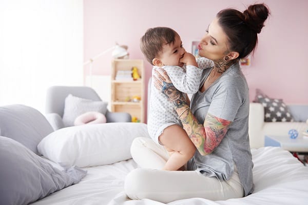 maman-tiens-bebe-jambes-lit